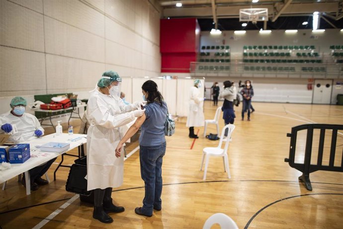 Empleados sanitarios vacunan a una compañera de profesión contra el Covid-19 en el pabellón Cabezo Baeza de Cartagena