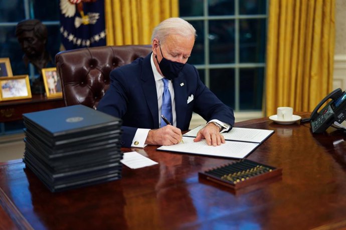 January 20, 2021 - Washington, DC, United States: United States President Joe Biden signs executive order on Covid-19 during his first minutes in the Oval Office, Wednesday, Jan. 20, 2021. President Biden as the 46th president of the United States. (Dou