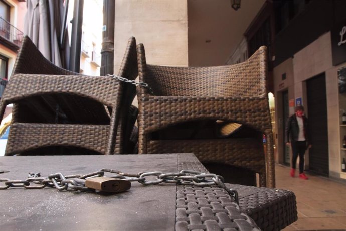 Un candado sostiene varias meses de un establecimiento cerrado en Logroño, La Rioja (España),