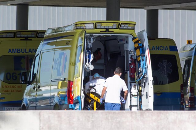 Un profesional sanitario baja de una ambulancia en camilla a un paciente con Covid-19