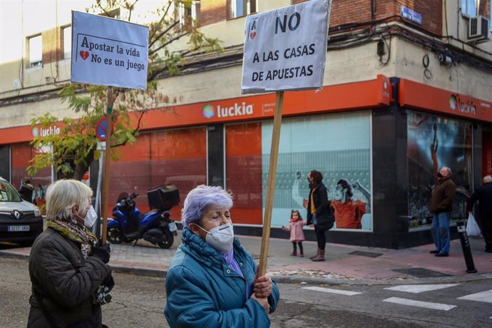 Una mujer sostiene una pancarta donde se lee que "Apostar la vida no es un juego" en una manifestación contra la proliferación de los locales de apuestas que ha tenido lugar en el barrio madrileño de Carabanchel, en Madrid (España), a 13 de diciembre.