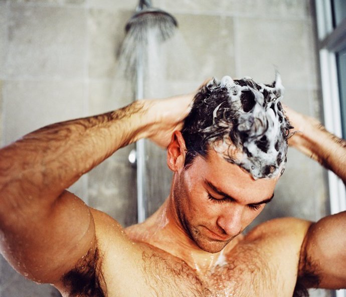 Close-up of a man washing his hair in the shower