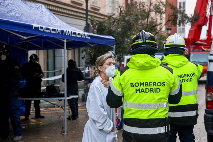 Dos bomberos y una sanitaria trabajan en la zona tras la explosión de ayer en la calle Toledo, en Madrid (España), a 21 de enero de 2021. La Policía Municipal de Madrid ha retirado esta mañana los vehículos dañados por los cascotes del edificio que expl