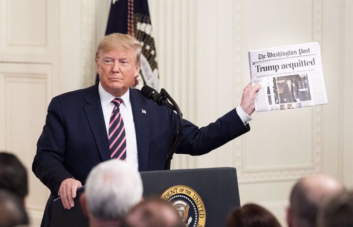 HANDOUT - 06 February 2020, US, Washington: US President Donald Trump holds up a copy of a newspaper during his statement at a press conference about his Senate impeachment trial in the East Room of the White House. Photo: Michael Brochstein/ZUMA Wire/d