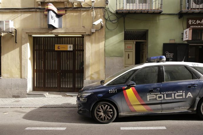 Un coche de policía junto a la entrada de una comisaría.