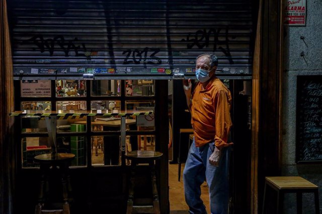 Un hombre cierra su restaurante el día en el que se adelanta el cierre de hostelería a las 22.00h.