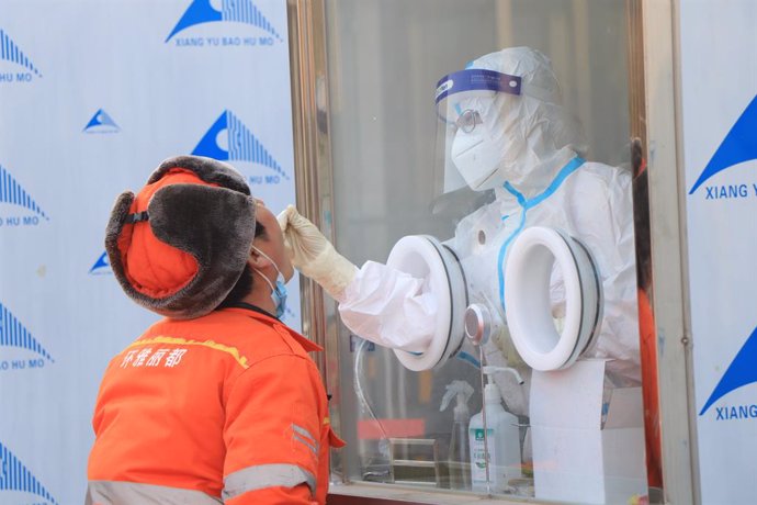 20 January 2021, China, Beijing: A health worker takes a swab from a man for the coronavirus (COVID-19) test at Xicheng district. Photo: -/TPG via ZUMA Press/dpa