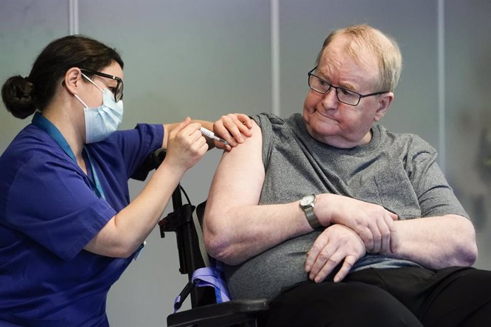 27 December 2020, Norway, Oslo: Nurse Maria Golding (l) vaccinates 67-year-old Svein Andersen with the Coronavirus vaccine from Biontech/Pfizer. Photo: Fredrik Hagen/NTB/dpa