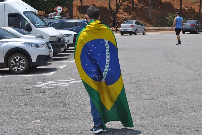 Un joven ataviado con la bandera de Brasil.