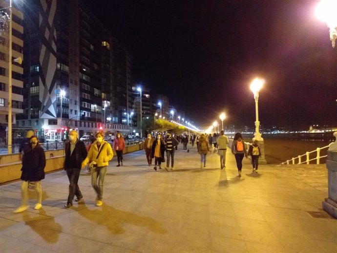 Vecinos de Gijón paseando por el Muro de San Lorenzo