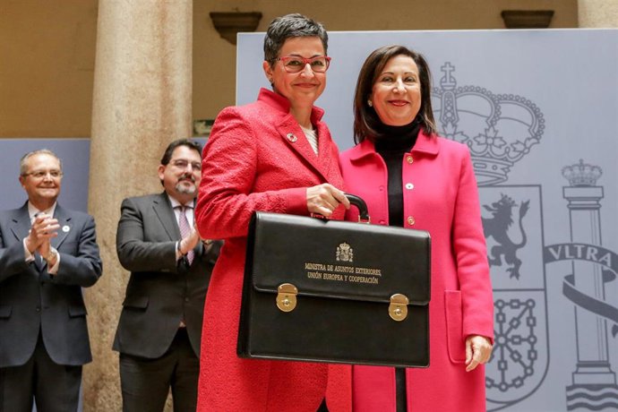 Arancha González Laya (i) sujeta la cartera del Ministerio de Asuntos Exteriores, Unión Europa y Cooperación, para el Gobierno de coalición de PSOE y Unidas Podemos en la XIV Legislatura, tras recibirla de manos de su predecesora en el cargo, Margarita 