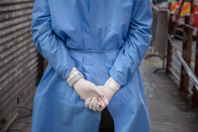 23 January 2021, China, Hong Kong: A health worker wearing latex gloves wait in an area where unprecedented lockdown has been declared by Hong Kong government in order to carry out compulsory coronavirus (COVID-19) testing in a designated zone.   