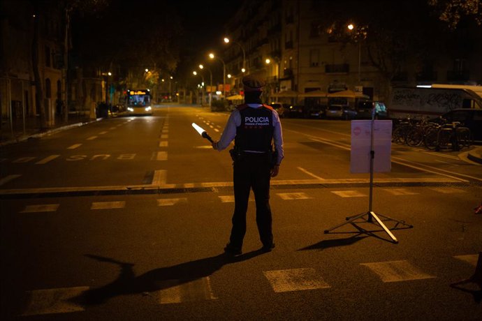 Un mosso d'Esquadra collabora en un control durant el toc de queda imposat per la crisi sanitria de la Covid-19.