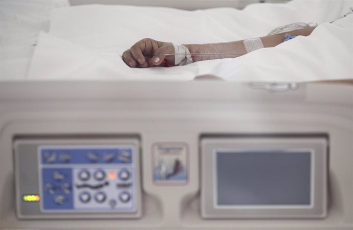 Mano de un enfermo con vía subcutánea en una cama de la UCI del Hospital de Emergencias Isabel Zendal, Madrid.