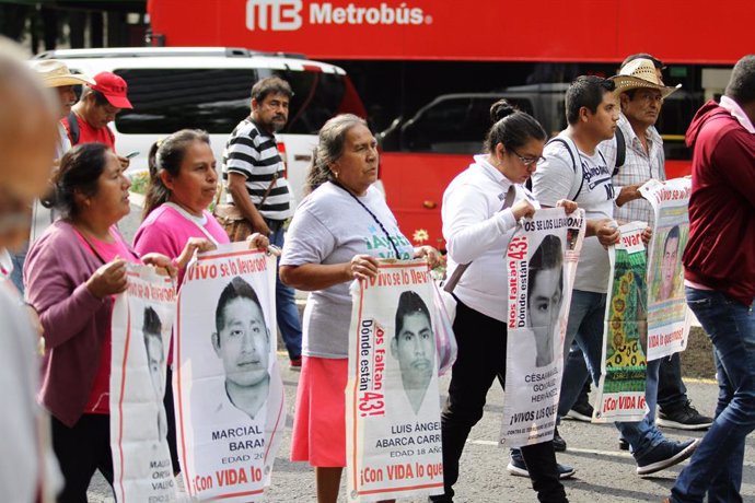 26 August 2019, Mexico, Mexico City: Relatives of the victims of the 2014 Iguala mass kidnapping protest with pictures of their disappeared family members. On 26 September 2014, 43 male students from the Ayotzinapa Rural Teachers' College were forcibly 