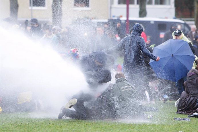 24 January 2021, Netherlands, Amsterdam: Demonstrators are sprayed by Dutch anti-riot police water cannons at Museumplein during a protest against the lockdown imposed to curb the spread of the coronavirus. Photo: Paulo Amorim/VW Pics via ZUMA Wire/dpa