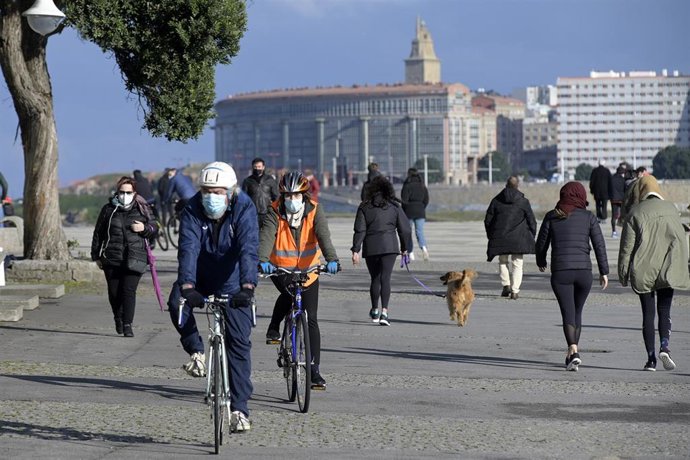 Varias personas caminan por un paseo marítimo en A Coruña, Galicia (España), a 10 de enero de 2021. En la jornada de este domingo, para la que se espera una ligera subida de las temperaturas, ya no habrá situación de alerta por frío en Galicia. Y es que