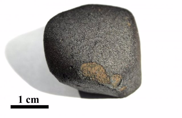 Meteorito de Flensburg con corteza de fusión negra: partes de la corteza de fusión se perdieron durante el vuelo a través de la atmósfera. El pequeño fragmento, que pesa 24,5 gramos, tiene unos 4.500 millones de años.