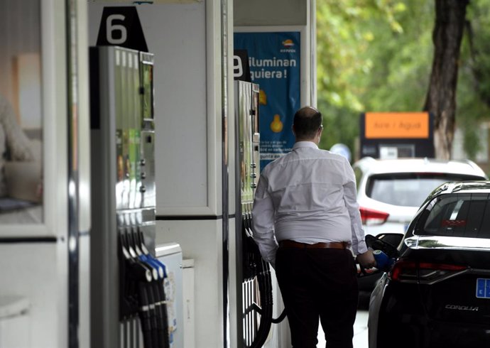 Un hombre echa gasolina a su coche en una gasolinera.