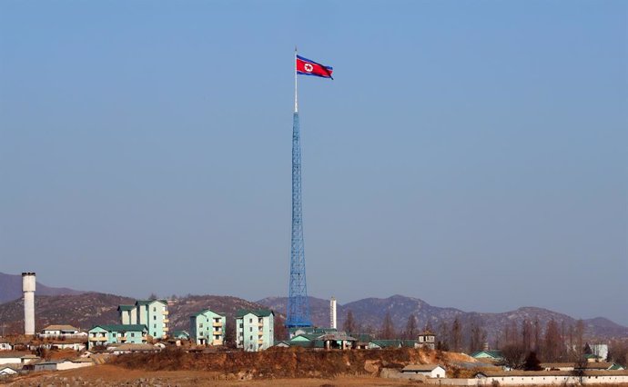 Una bandera de Corea del Norte ondeando sobre un edificio.