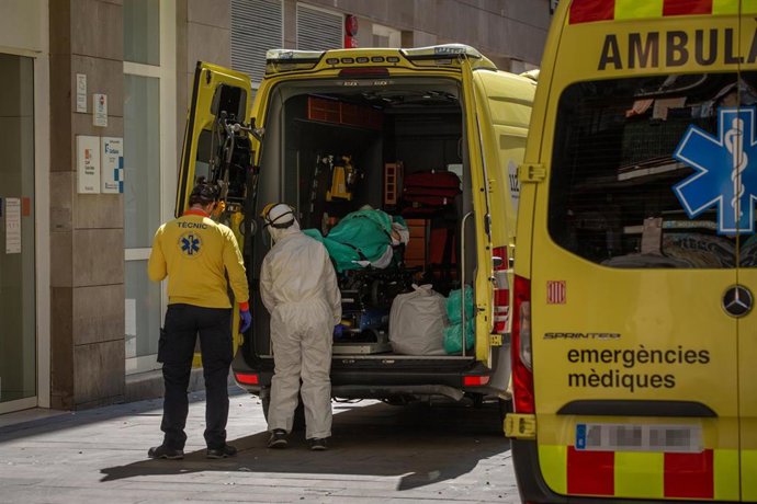 Dos sanitarios en la puerta de una ambulancia en la que hay un paciente con coronavirus en el Centro de Emergencias de Atención Primaria Pere Camps en el Raval, en Barcelona/ 6 de abril de 2020.