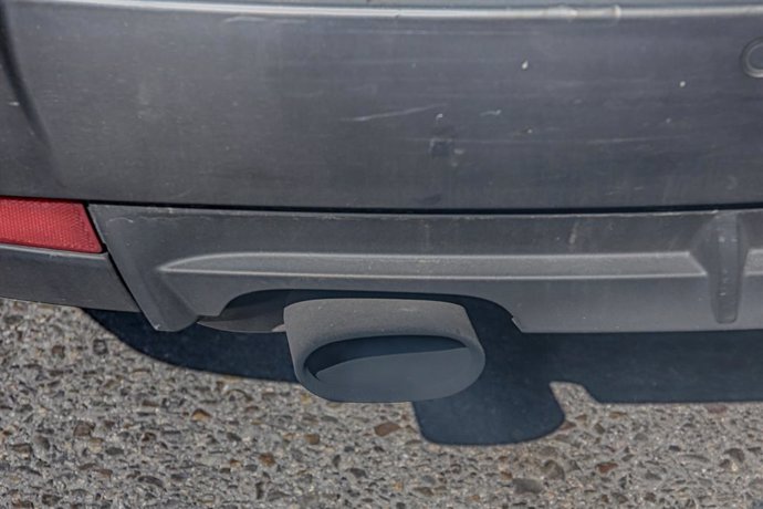 Tubo de escape de un coche emitiendo polución.