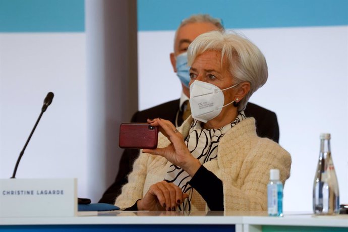 11 January 2021, France, Paris: President of the European Central Bank (ECB) Christine Lagarde holds her smartphone as she attends the One Planet Summit, part of World Nature Day, at the Reception Room of the Elysee Palace. Photo: Ludovic Marin/AFP/dpa