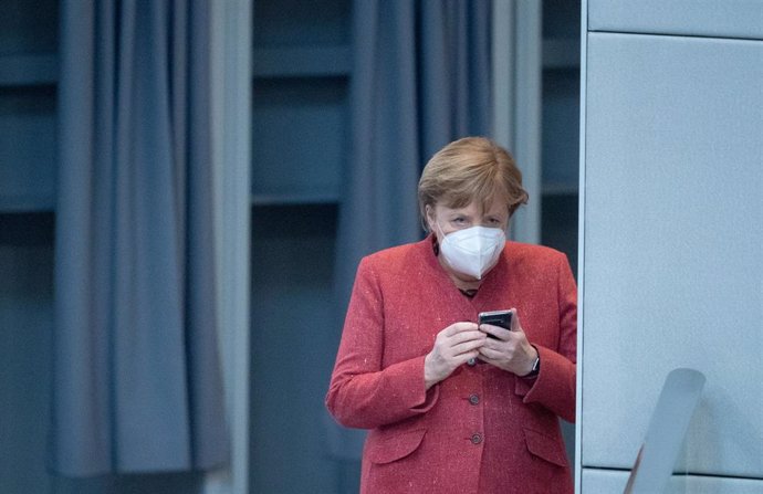 Angela Merkel revisa su teléfono móvil durante una sesión en el Bundestag
