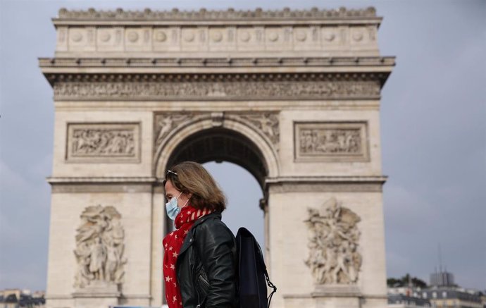 Una mujer con mascarilla ante el Arco del Triunfo de París
