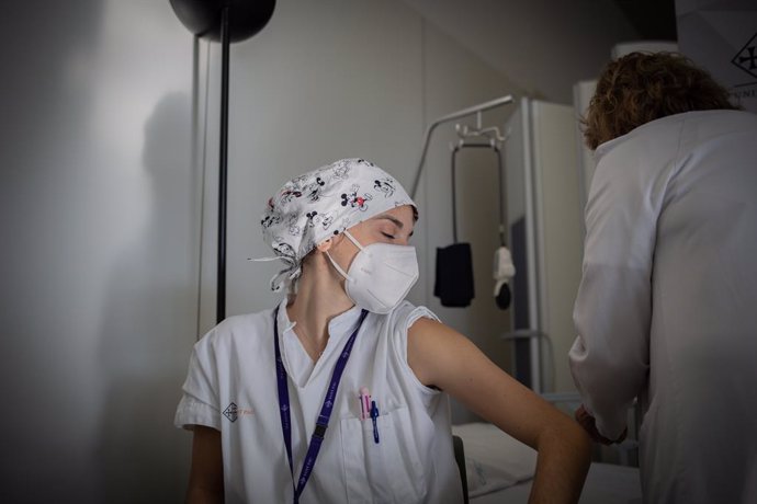 Una infermera vaccina un professional sanitari contra la covid-19 a l'Hospital de la Santa Creu i Sant Pau de Barcelona. Catalunya (Espanya), 14 de gener del 2021.