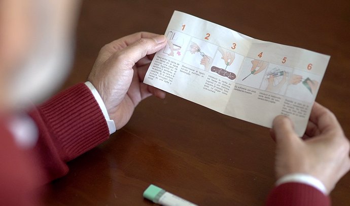 Un hombre lee el folleto con la información sobre el cribado del cáncer de colon