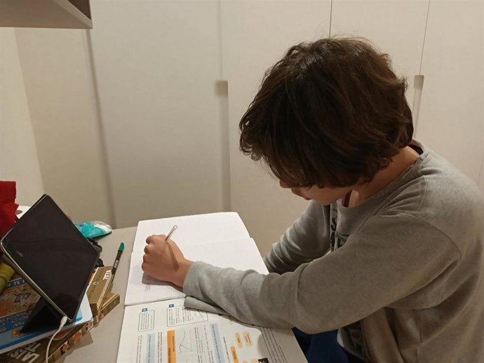 Un alumno trabaja en casa con un ordenador durante el confinamiento por la pandemia