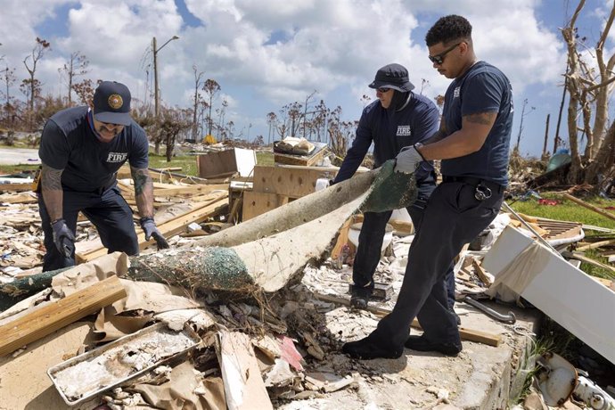 17 September 2019, US, Grand Bahama: West Palm firefighters Scott remove the debris from a house that was torn down by Hurricane Dorian. The hurricane hit the northern islands of the Bahamas in the Caribbean and left devastating damage there. Photo: Gre