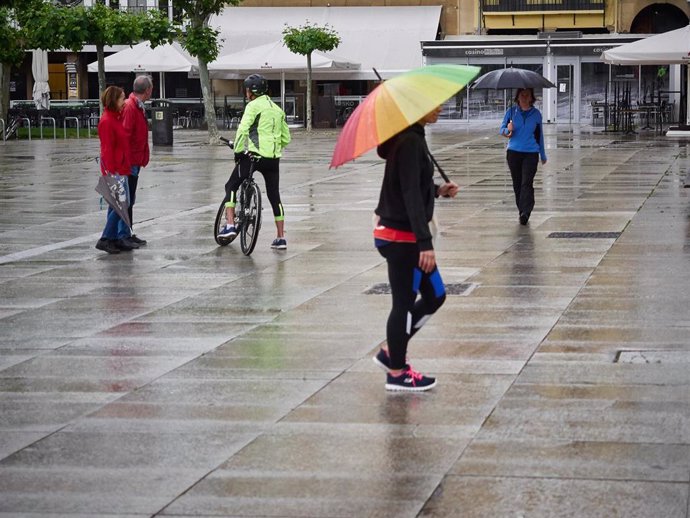 Varias personas caminan con paraguas por la Plaza del Castillo de Pamplona,  a 10 de mayo de 2020.