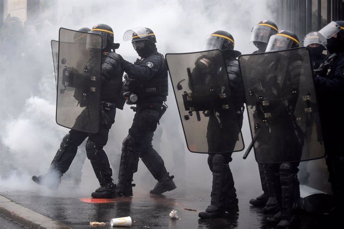 16 January 2021, France, Nantes: Smoke from tear gas bombs surrounds anti-riot police officers during a protest against the global security draft law that would restrict publication of pictures showing the faces of police officers on duty. Photo: Sebast