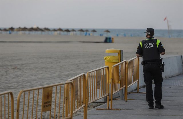 Un policía local hace guardia en la playa de la Malvarrosa durante la noche de San Juan en Valencia, Comunidad Valenciana  (España), a 23 de junio de 2020. Unos 200 agentes de Policía en Valencia blindan las playas de la ciudad en San Juan para evitar agl