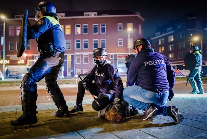 25 January 2021, Netherlands, Rotterdam: A man is arrested by Police during clashes following the Nationwide protest against coronavirus restrictions and curfew imposed by the Dutch government amid the spread of the COVID-19 pandemic. Photo: Marco De Sw