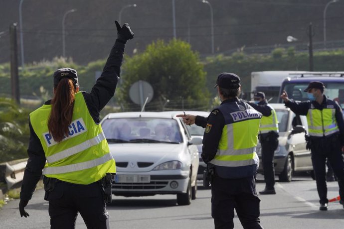 Varios agentes de Policía Nacional dan el alto a un vehículo en un control de movilidad en la parroquia de O Castiñeiriño, en Santiago de Compostela.