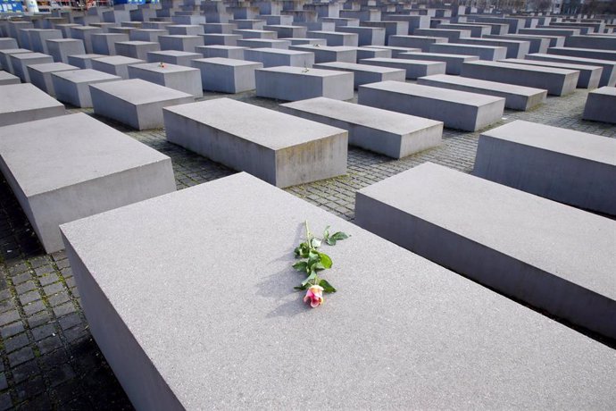 27 January 2021, Berlin: Individual roses lie on some of the stelae of the Memorial to the Murdered Jews of Europe on the International Day of Commemoration in memory of the victims of the Holocaust. Photo: Wolfgang Kumm/dpa