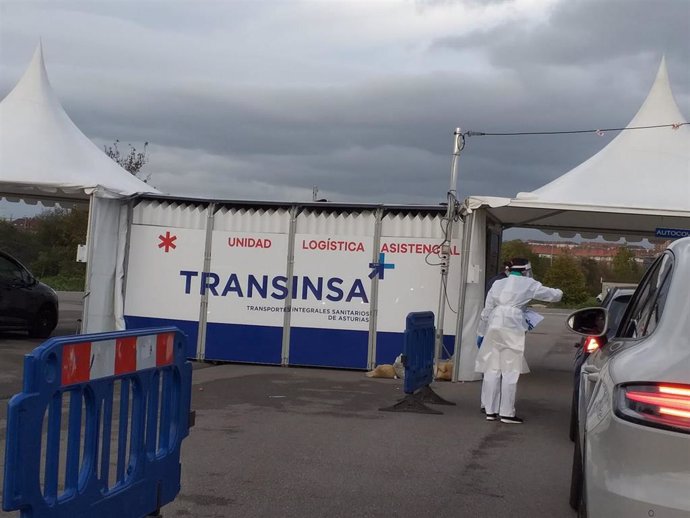 Carpa de Transinsa en la que se ha instalado un Autocovid en Gijón, con coches esperando a la realización de las PCR.