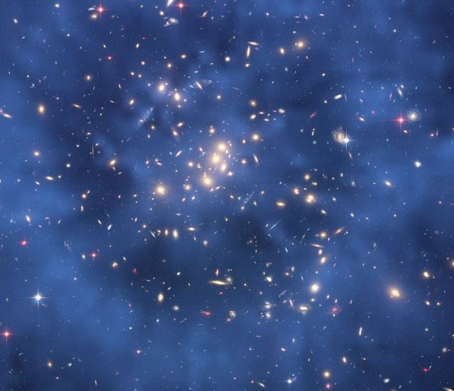 Imagen compuesta del cúmulo de galaxias CL0024+17 tomada por el telescopio espacial Hubble que muestra la creación de un efecto de lente gravitacional. Se supone que este efecto se debe, en gran parte, a la interacción gravitatoria con la materia oscura.