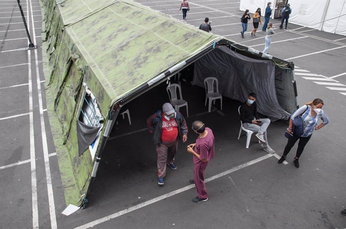 15 January 2021, Ecuador, Quito: Doctors speak with patients in front of a waiting room set up in a tent in front of the Iess South Hospital. Photo: Juan Diego Montegro/