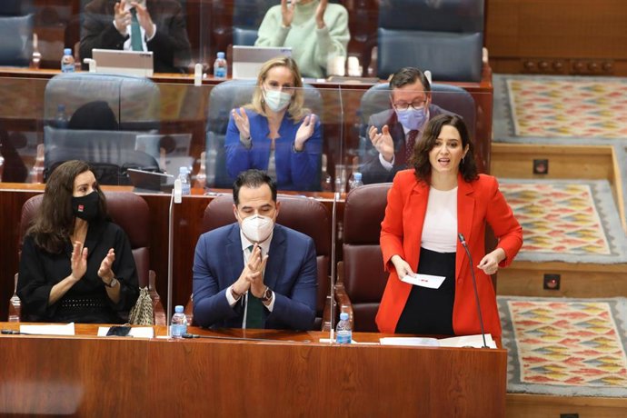 La presidenta de la Comunidad de Madrid, Isabel Díaz Ayuso (1d), acompañada del vicepresidente, Ignacio Aguado (2d), y del portavoz del PP, Alfonso Serrano (detrás), interviene durante una sesión plenaria en la Asamblea de Madrid (España), a 28 de enero