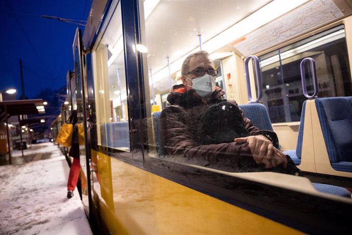 25 January 2021, Stuttgart: A commuter wearing a face mask sit in a commuter train. Photo: Sebastian Gollnow/dpa