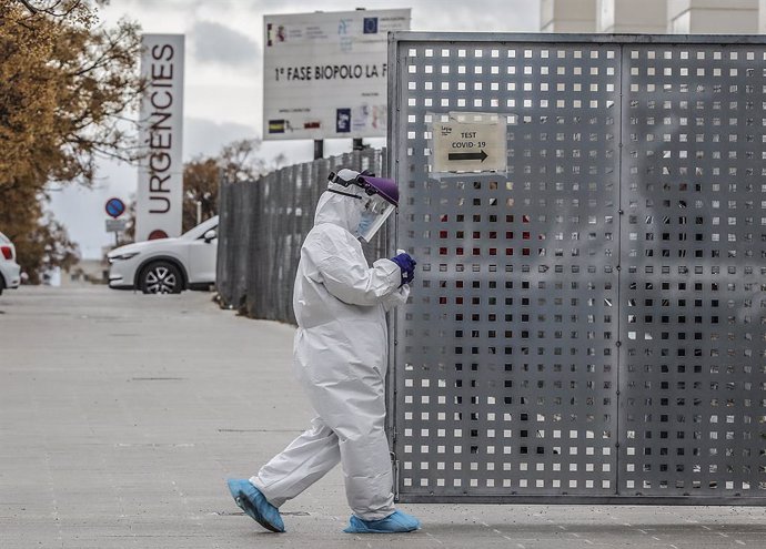 Un sanitario a los alrededores de la fila de vehículos para realizarse una prueba PCR de detección del coronavirus a las puertas del Hospital de Campaña próximo al de La Fe, en Valencia (España), a 25 de enero de 2021. Los contagios de COVID-19 en la Co