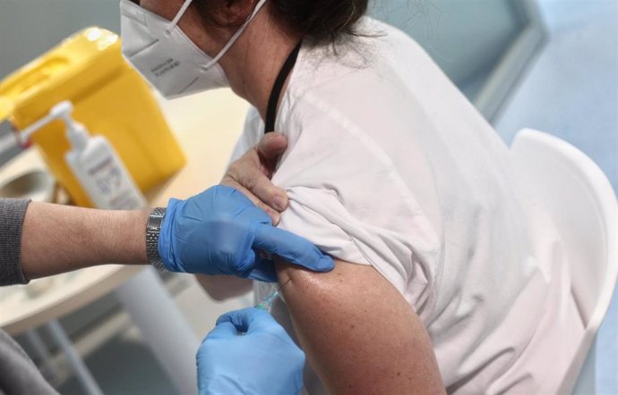 Una enfermera vacuna a la doctora Lara Gutiérrez en las instalaciones del Hospital Enfermera Isabel Zendal, en Madrid, (España), a 12 de enero de 2021. Hoy es el tercer día que se están administrando vacunas en este hospital después de que la gran nevad