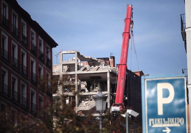 Una grúa trabaja en la demolición de la planta sexta del edificio de la calle Toledo 98 que, el pasado día 20 sufrió una explosión por un escape de gas, en Madrid (España), a 27 de enero de 2021.  Los vecinos del bloque de viviendas número 102 podrán volv