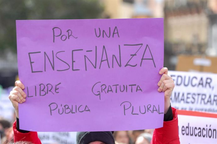 Jóvenes con pancartas en las que se pueden leer "Por una enseñanza libre, gratuita, pública y plural".