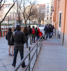 Fila de personas vulnerables para recoger la bolsa de comida de Navidad que reparte la organización SANT'EGIDIO, en la Iglesia Nuestra Señora de las Maravillas, en Madrid (España), a 25 de diciembre de 2020.