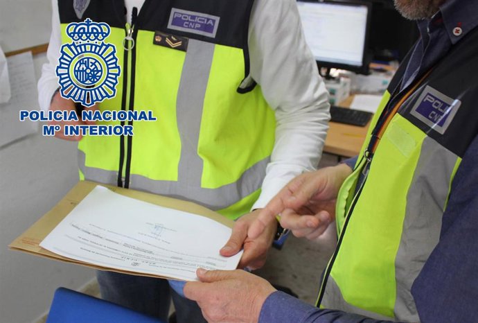 Agentes de la Policía Nacional revisan un contrato de alquiler fraudulento